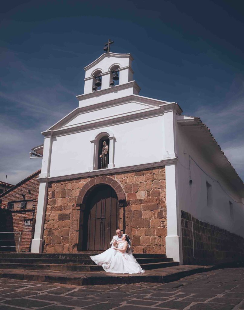 Pareja en la capilla San Antonio con técnica de compensación de exposición para capturar el cielo azul y la capilla con alto rango dinámico